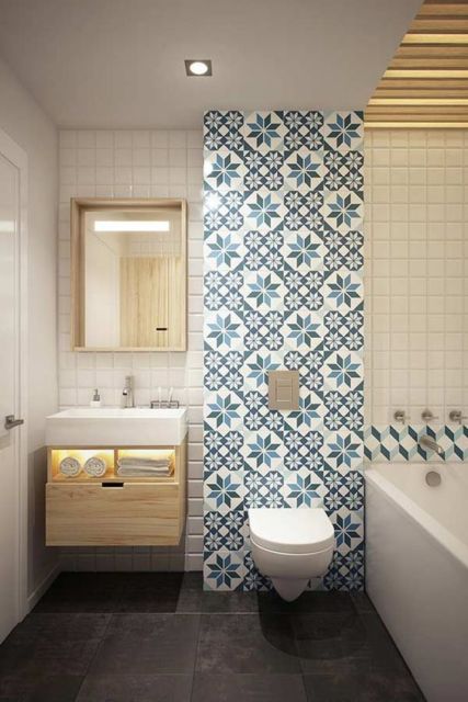 banheiro com louças brancas e faixa de ladrilho hidráulico em tons de azul