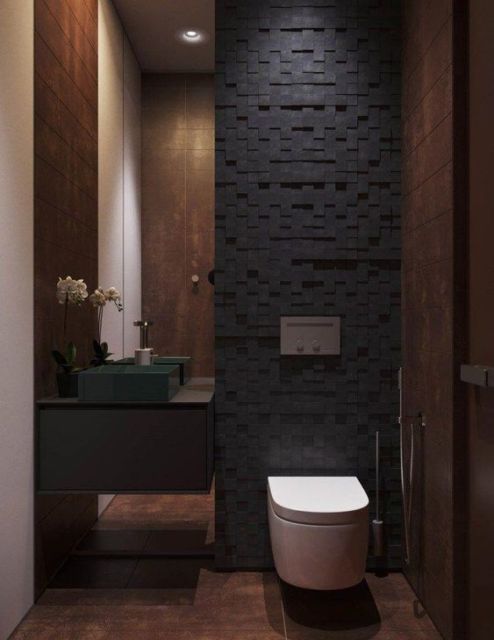 louça sanitária branca com parede de pedras pretas por trás, recortadas em pequenos quadrados em diferentes angulações