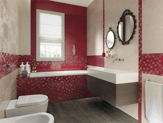 banheiro com louças brancas, pastilhas e zulejos em cor fúcsia escura, dois espelhos redondos com moldura preta sobre a pia e piso de madeira