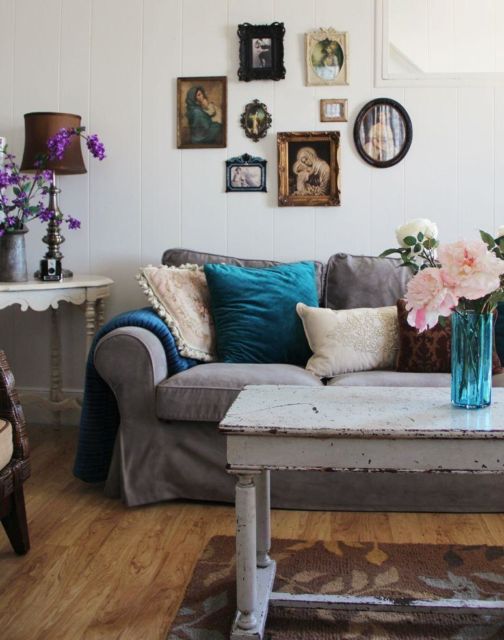 sala com móveis antigos, sofá cinza e composição de quadros na parede