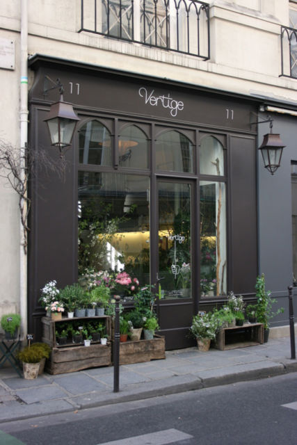 fachada preta com plantas na frente compondo a decoração da loja