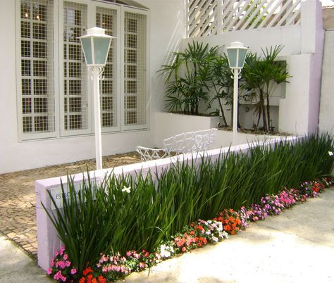 casa branca com jardim com planta verde e flores de diversas cores