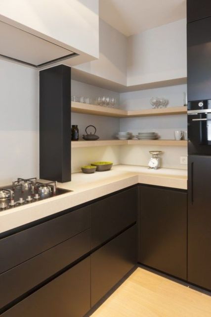 cozinha com armários pretos e balcão branco, fogão de placa e utensílios à mostra
