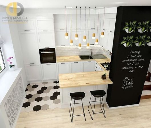 pequena cozinha americana com armários brancos, balcão em madeira clara, bancos pretos e parede de lousa preta