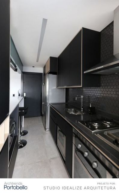 cozinha com armários pretos, piso claro, teto branco e fogão de placa