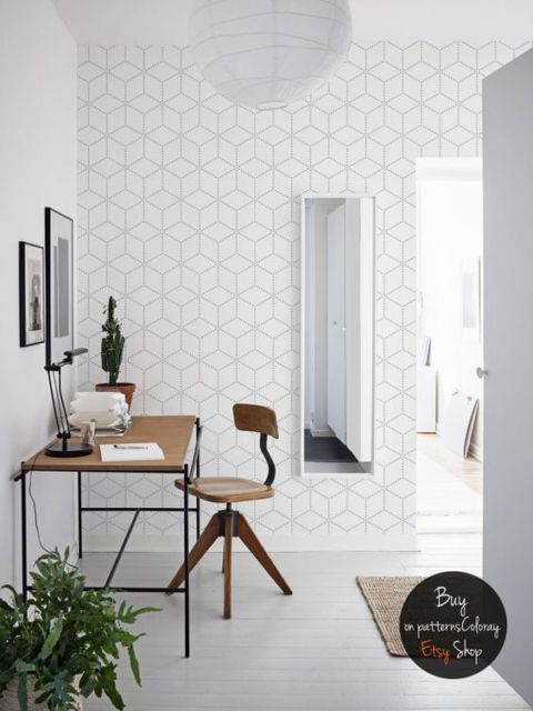 mesa e cadeira de madeira, quadros de moldura preta na parede, espelho vertical fino e paredes e piso brancos