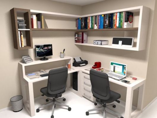 pequeno escritório cm duas mesas que se encontram no canto do cômodo, duas cadeiras de escritório cinza e estantes suspensas