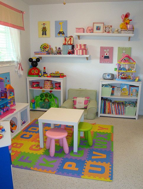 quarto de criança, com tapete colorido, pequena mesinha branca com banquinhos rosa e verde claros