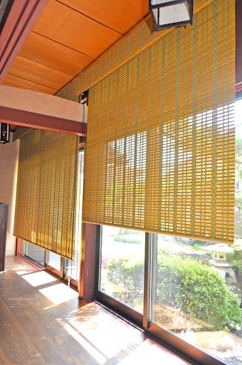 grandes portas de vidro com cortinas de bambu em tom claro