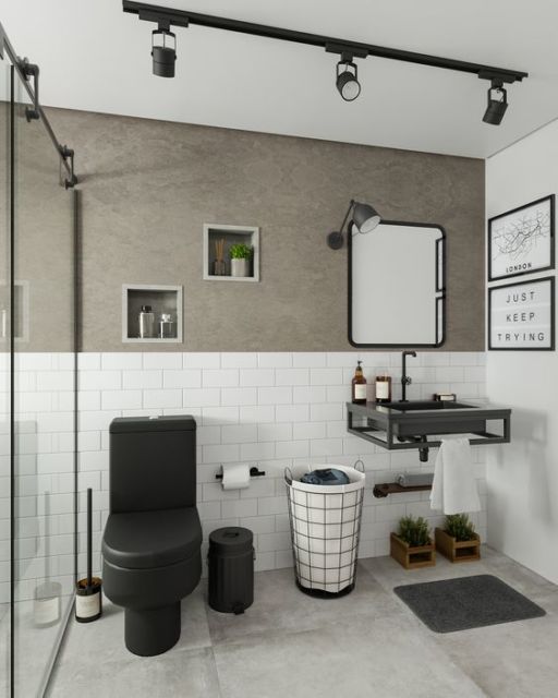 banheiro com vaso sanitário preto, espelho retangular e parede cinza