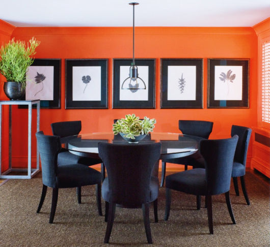 sala de jantar laranja com quadros
