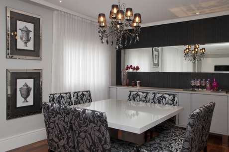 sala de jantar preta e branca com cadeiras estampadas