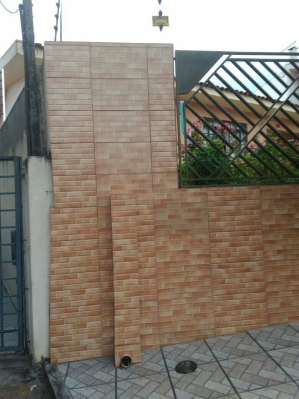 fachada de casa com muro de piso de tijolinho