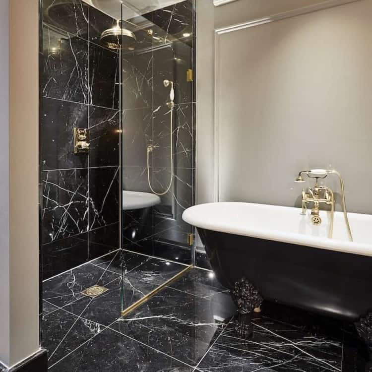 banheiro com mármore preto e banheira vitoriana
