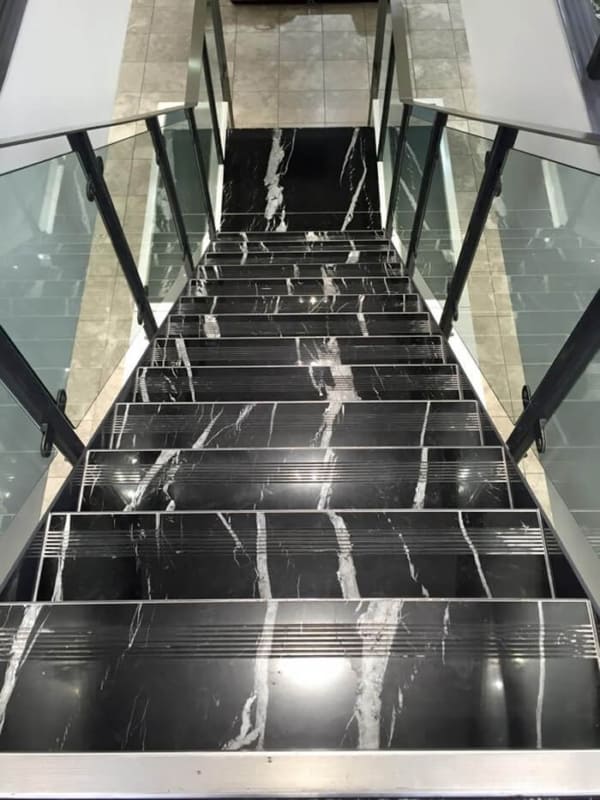 escada de mármore preto com guarda corpo de vidro