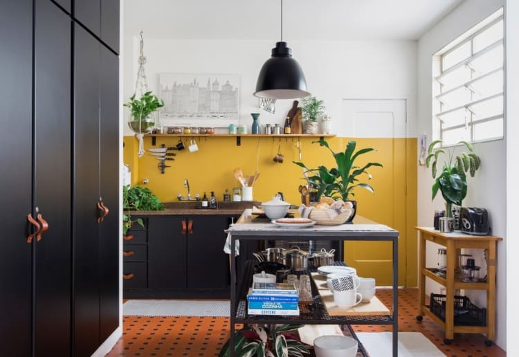 cozinha com parede amarela e armarios em preto