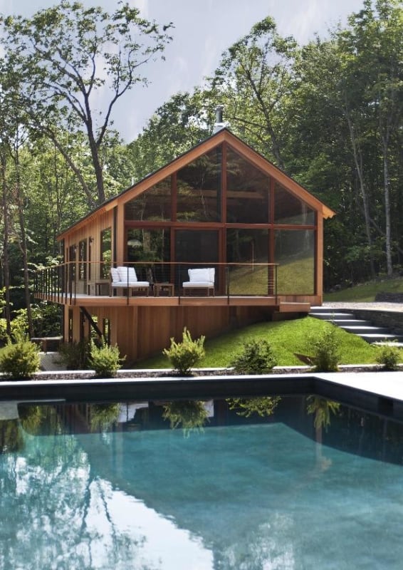 casa de vidro com piscina na floresta