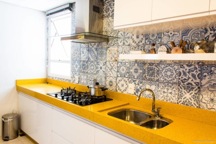 cozinha com bancada amarela e armarios brancos