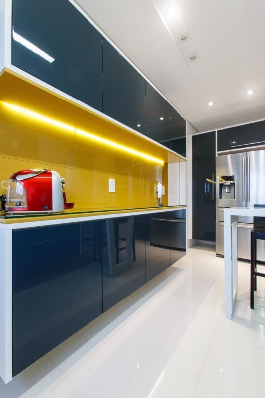 cozinha com rodabanca amarela e armarios em azul petroleo