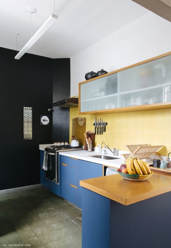 cozinha com revestimentos amarelos e armario azul