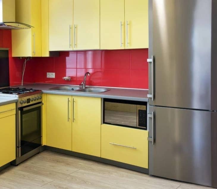 cozinha com armarios amarelos e revestimento vermelho