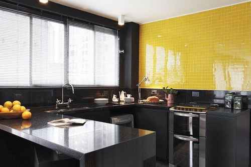 cozinha com pastilhas amarelas na parede e armarios em preto