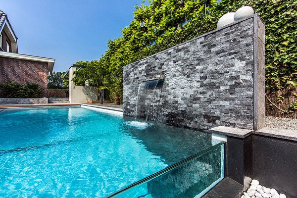 piscina elevada moderna com parede de vidro e cascata