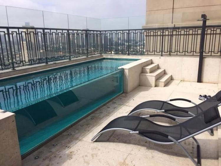 piscina de alvenaria elevada com parede de vidro