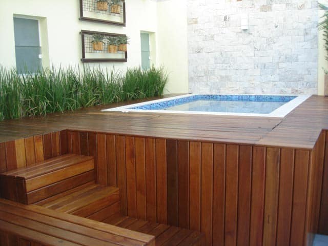 piscina quadrada elevada com deck de madeira