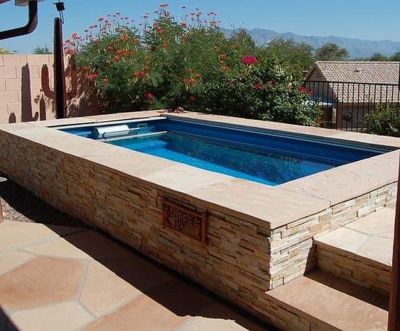 piscina acima de alvenaria acima do solo com pedras
