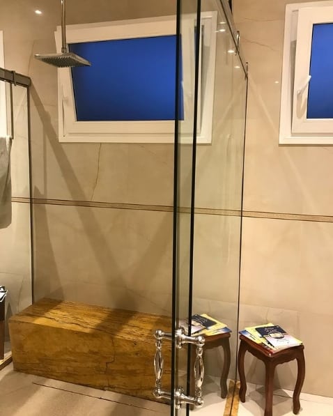banheiro luxuoso com chuveiro de teto cromado