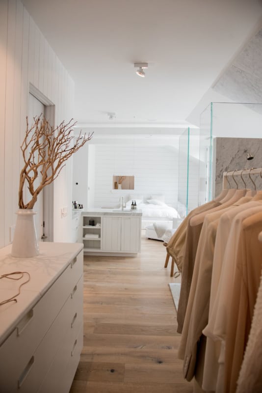 quarto de casal clean e branco com closet e banheiro