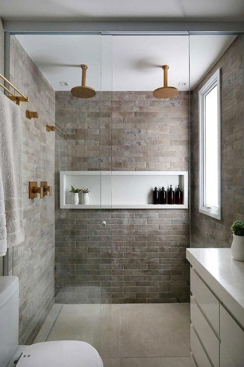 banheiro de casal com chuveiros de teto dourados