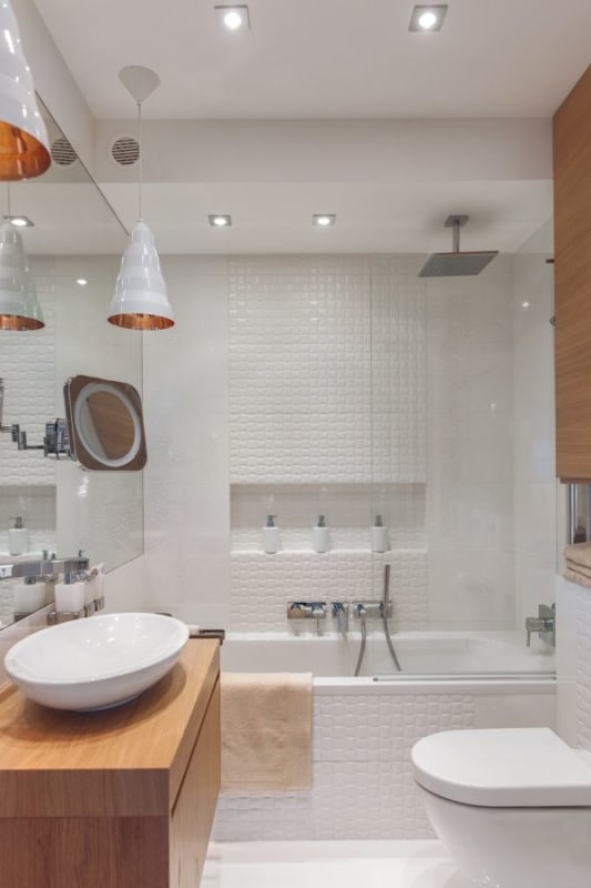 banheiro branco com banheira e chuveiro de teto