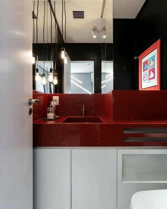banheiro com paredes pretas e bancada vermelha