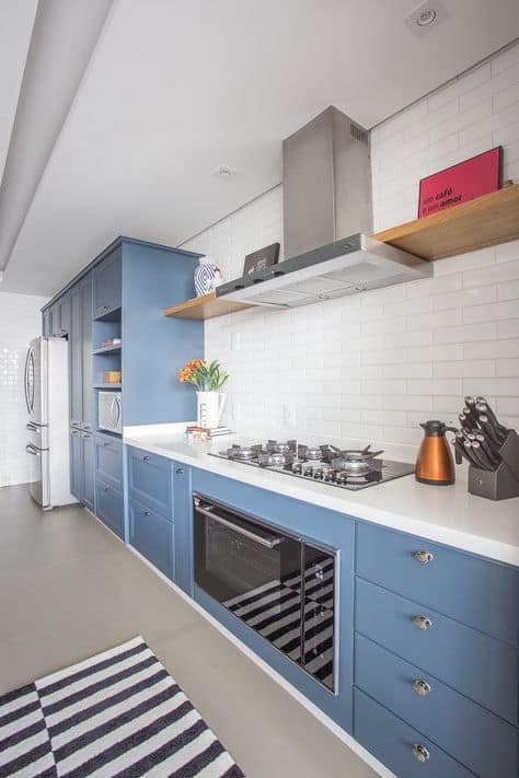 cozinha com armarios azul e azulejo de metro branco