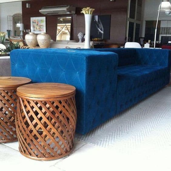 sala com sofa azul e garden seat de madeira