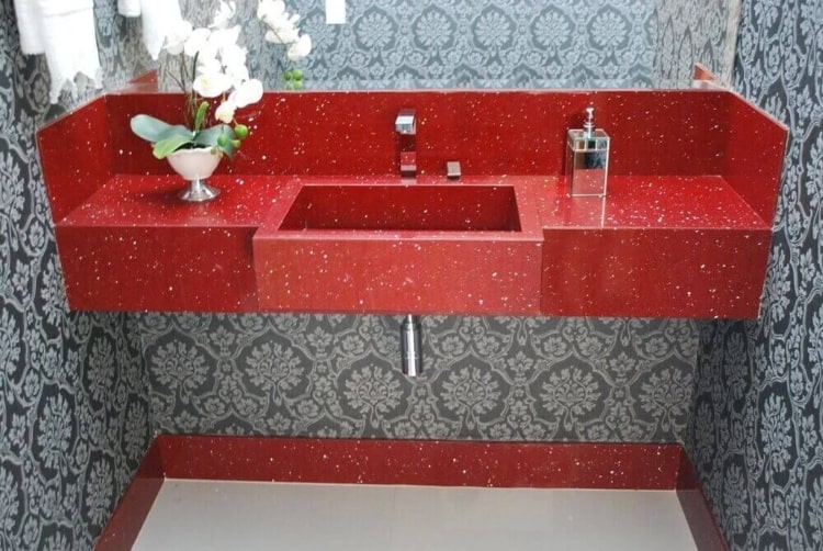 banheiro com bancada vermelha e papel de parede cinza