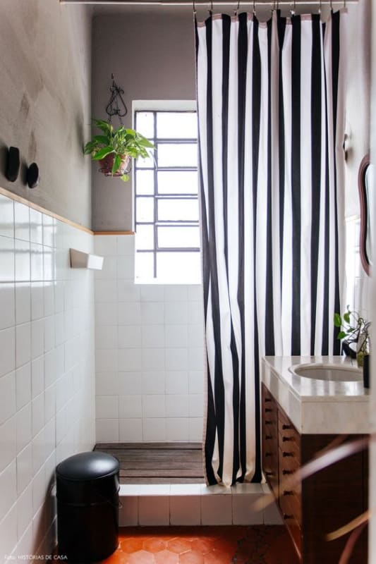 box de banheiro com cortina de listras em preto e branco