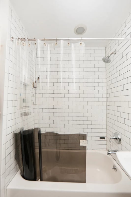 banheiro com banheira pequena e cortina transparente
