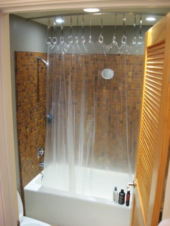 banheiro com banheira e cortina transparente