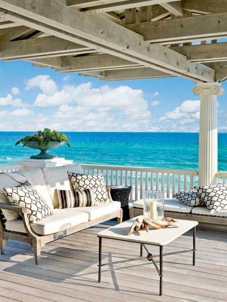Casas de praia: Decoração de varanda com mesa e sofá