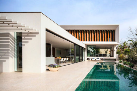 Casas com piscina: casa em l com janela de madeira