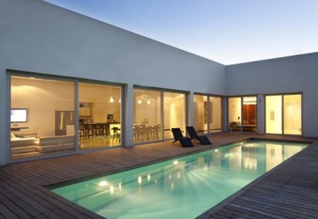 Casas com piscina: casa em l com porta de vidro