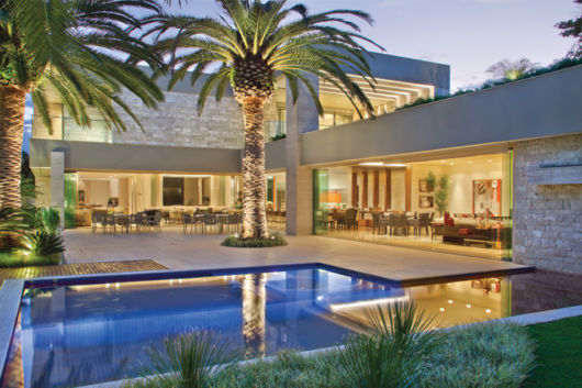 Casas em L: Com varanda e palmeiras