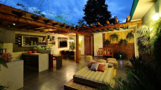 Casas em L: Com varanda rústica