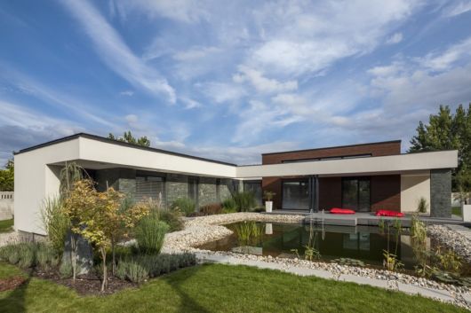 Casas em L: Fachada com lago artificial