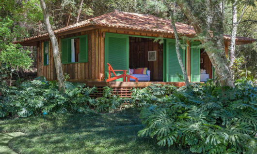 Casa pequena de madeira com as janelas verdes