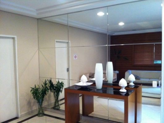 Decoração de sala pequena: Com espelho na parede inteira