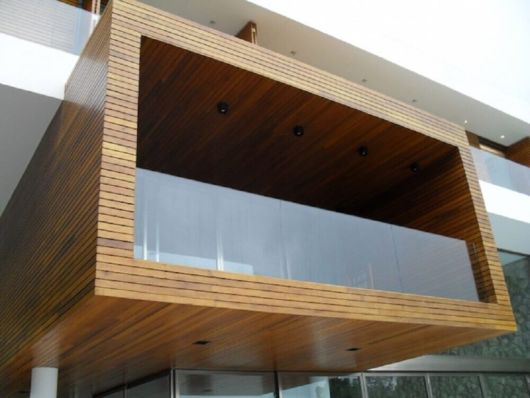 Guarda-corpo de vidro: Em sacada com revestimento de madeira